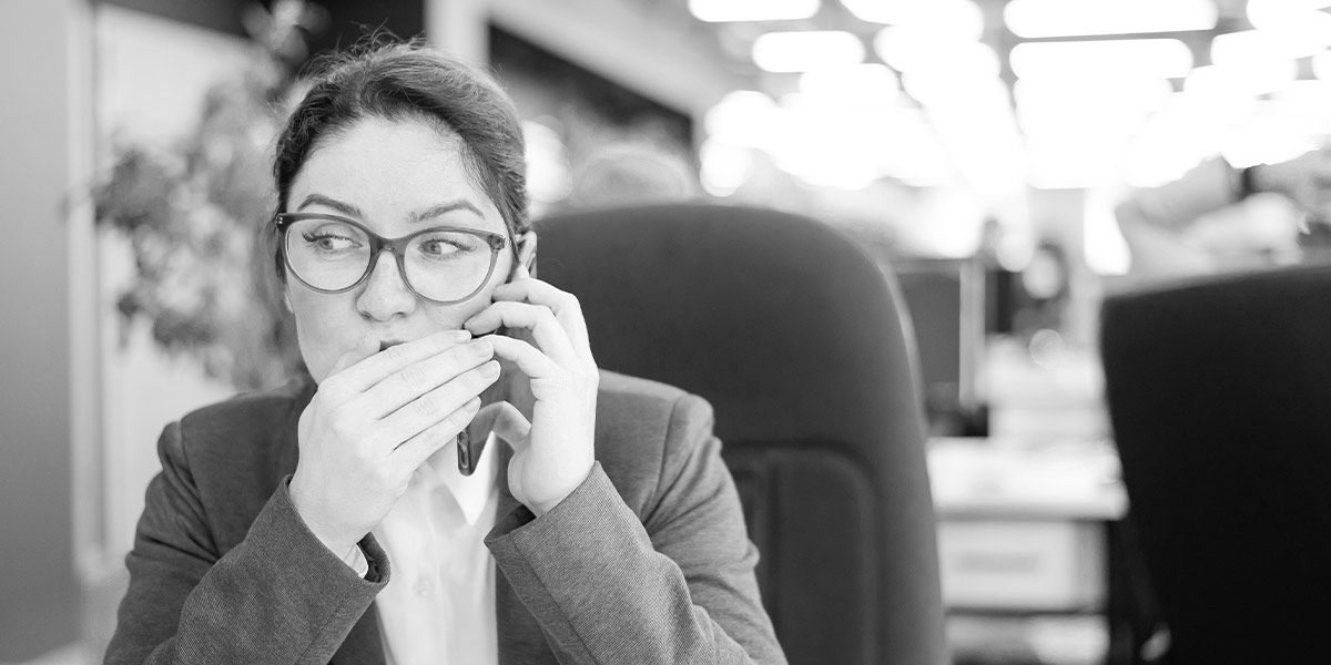 Junge Frau im Büro, die aufgrund nicht eingeschalteter Access Based Enumeration einen Ordner mit top secret Inhalten sehen konnte und jetzt mit jemandem telefoniert.