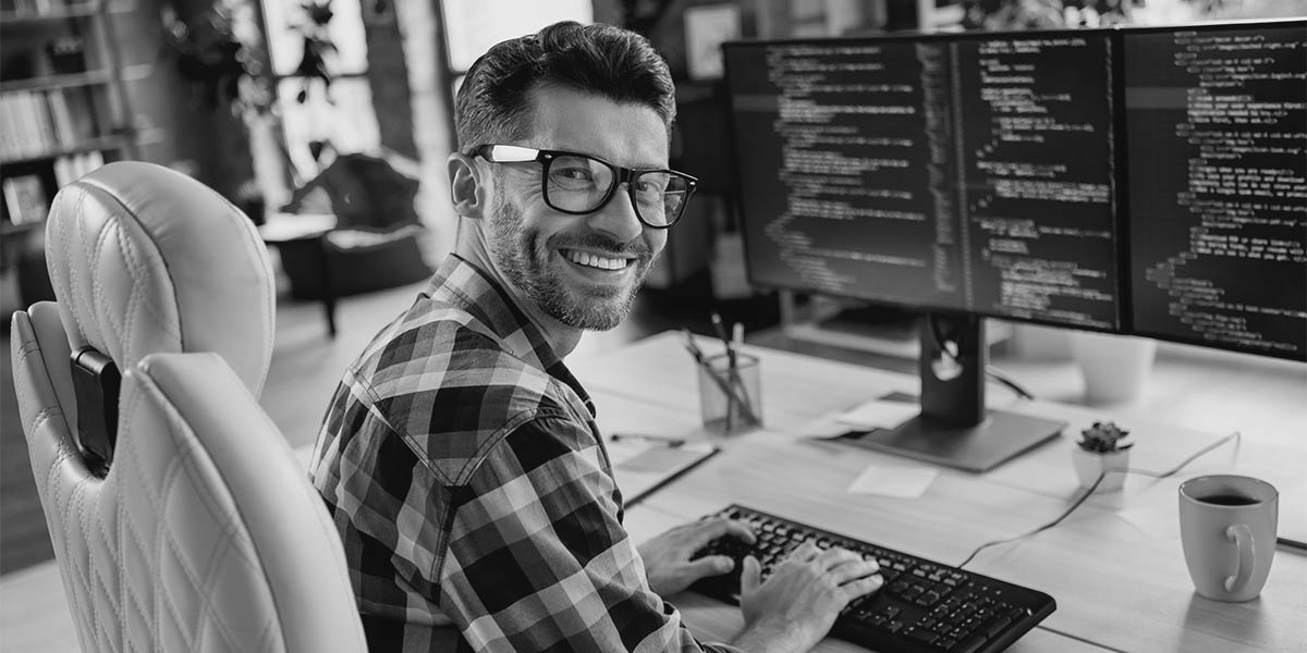 A smiling sysadmin at their workstation.