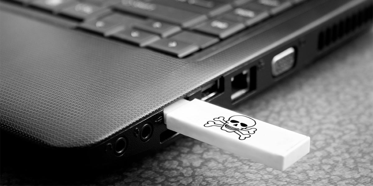 USB Stick mit Totenkopf-Icon in einem Firmenlaptop