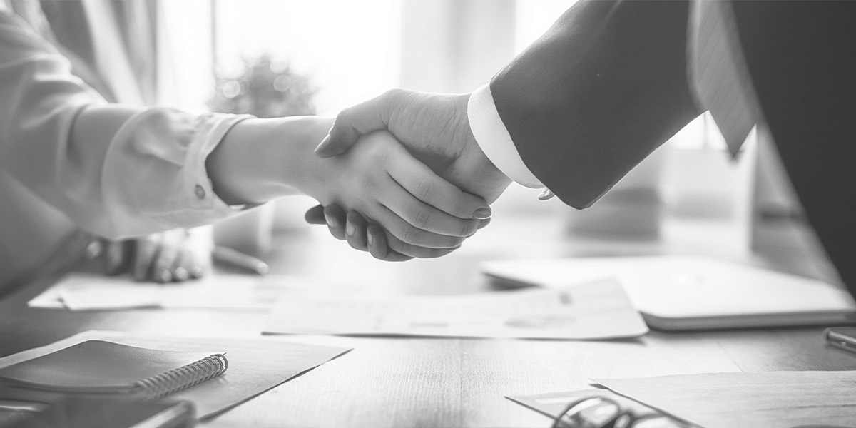 Business Meeting, bei dem sich zwei Geschäftsleute die Hände reichen.