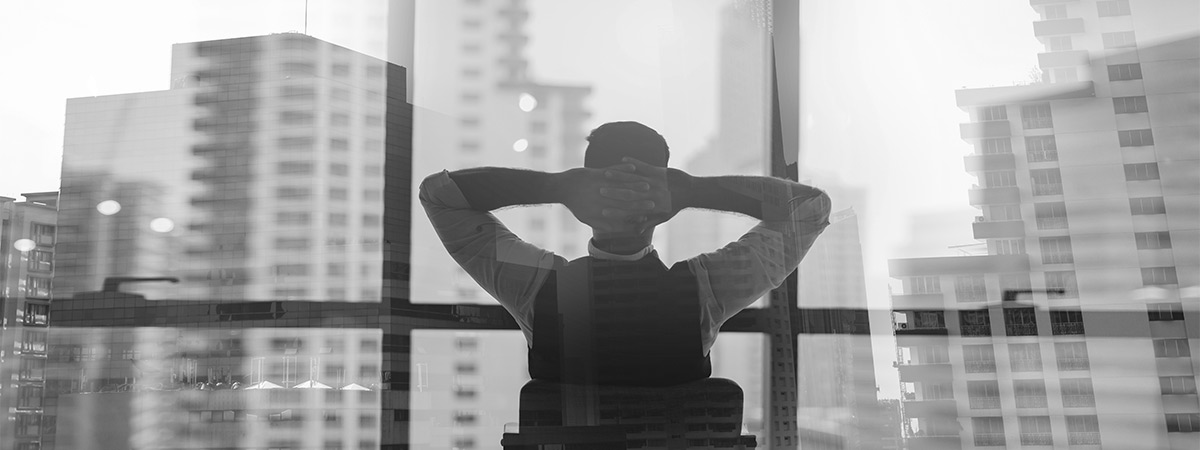 Geschäftsmann, der entspannt an seinem Schreibtisch sitzt, weil er weiß, dass seine Software für Identity and Access Management die Sicherheitslücken in seinem Unternehmen schließt.