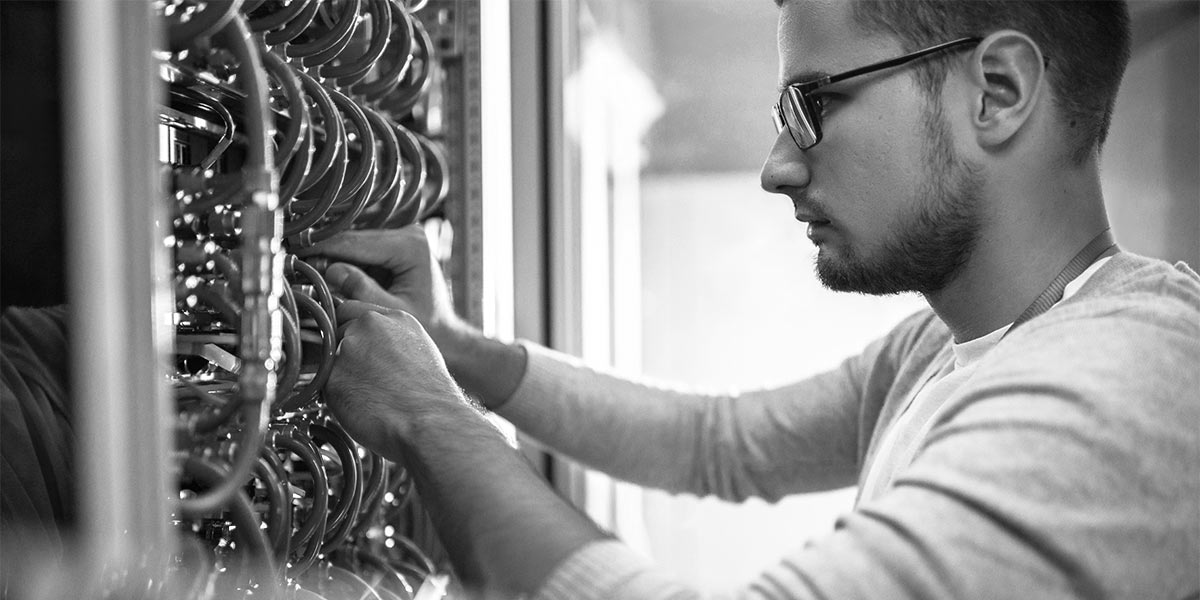 IT technician doing maintenance on a server rack.